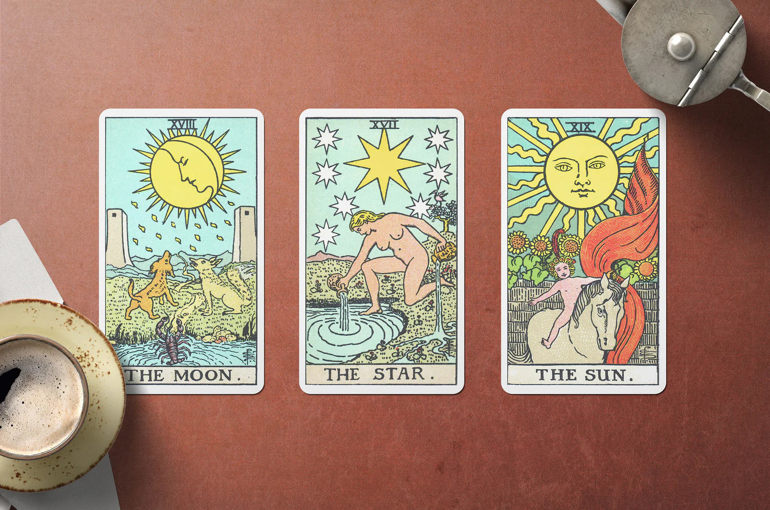 Three tarot cards laid out on a table, depicting 'The Moon', 'The Star', and 'The Sun' with artistic illustrations corresponding to each card's traditional meaning in tarot.